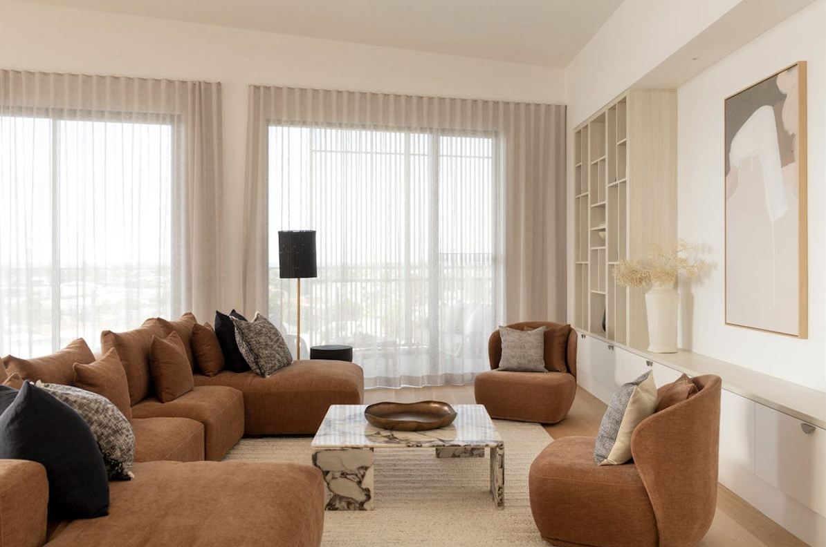 rich warm brown coloured sofa and matching armchairs in pelican waters penthouse, property styling by blink living